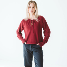 Load image into Gallery viewer, Woman wearing a red sweater and blue pants on a white background
