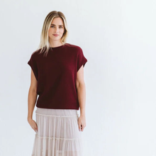 Load image into Gallery viewer, Woman wearing a burgundy top and white skirt on a light gray background

