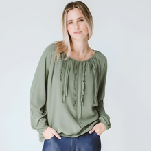 Load image into Gallery viewer, Woman wearing a green blouse with ruffled details against a plain background
