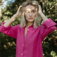Load image into Gallery viewer, Woman wearing a bright pink dress with trees in the background

