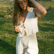 Load image into Gallery viewer, Woman in a white outfit standing in a grassy field
