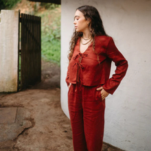 Load image into Gallery viewer, Woman wearing a red outfit standing against a white wall.
