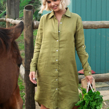 Load image into Gallery viewer, Woman in a green dress standing next to a horse, holding greens.
