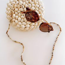 Load image into Gallery viewer, Sunglasses with a beaded chain on a textured white surface
