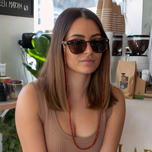 Load image into Gallery viewer, Woman wearing sunglasses with a coffee shop setting in the background
