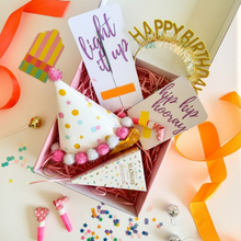Load image into Gallery viewer, Birthday-themed gift box including a hat, noisemaker, and confetti in a box on a light background.

