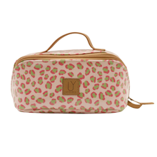 Load image into Gallery viewer, A pink and green leopard print toiletry bag with a tan handle and zipper, featuring a brown leather patch with the IY logo, on a white background.
