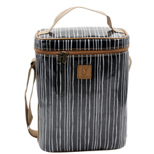 Load image into Gallery viewer, A rectangular soft-sided cooler bag with a black and white vertical stripe pattern, tan handle and shoulder strap, and a small tan brand patch on the front.
