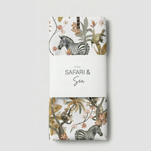 Load image into Gallery viewer, A folded table runner wrapped with a white paper band reading 'SAFARI &amp; Sea' and 'EST. 2022'.
