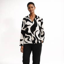 Load image into Gallery viewer, Woman wearing a black and white patterned blouse against a white background
