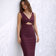 Load image into Gallery viewer, Woman wearing a burgundy dress against a white textured wall
