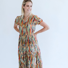 Load image into Gallery viewer, Woman wearing a colorful patterned dress against a white background
