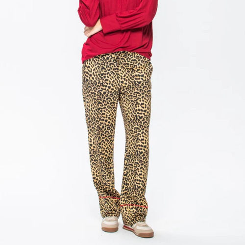 Person wearing red top and leopard print pants on a white background