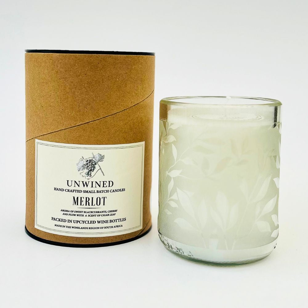 Candle in a glass jar with a cardboard tube packaging labeled 'Unwined Merlot' on a white background.
