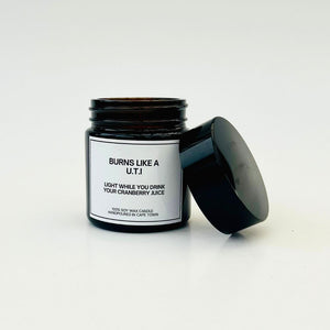 Candle in a black jar with a white label on a light gray background