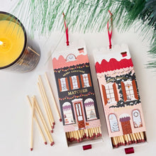 Load image into Gallery viewer, Two Christmas-themed matchboxes with matches on a white surface with greenery.
